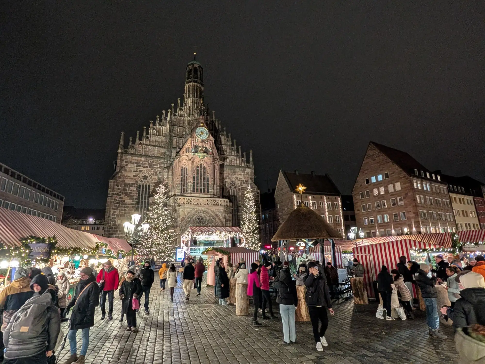 The Christkindlesmarkt in Nuremberg at night, stalls lit in front of the Frauenkirche, photographed on one of our own trips