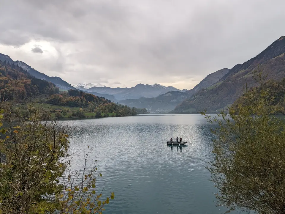 A boat out on the water, mountains beyond