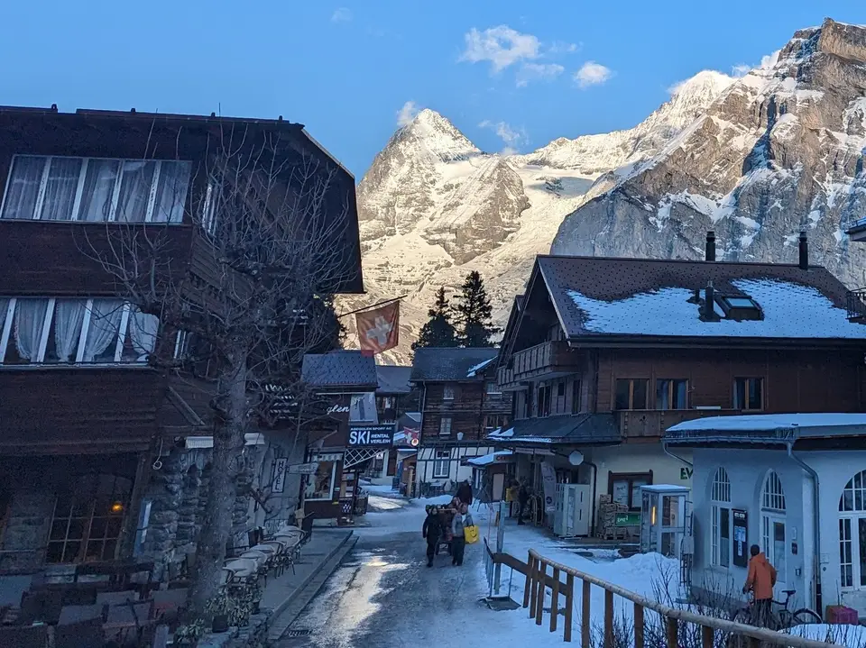 The village street in snow, shopfronts and the peaks beyond
