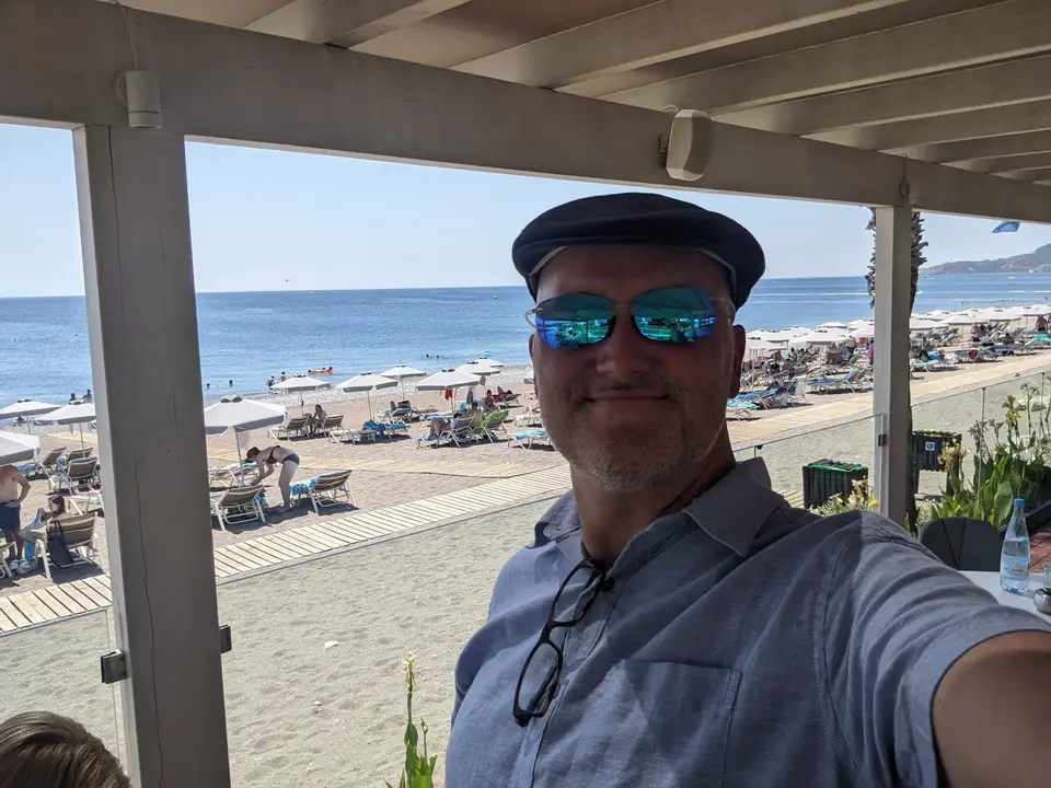 Under the beach bar roof, the loungers behind